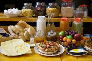 una mesa cubierta con platos de comida y otros alimentos en Casa Volante Hostal en Valparaíso