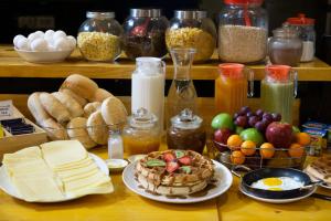 a table topped with plates of food and other foods at Casa Volante Hostal in Valparaíso