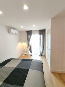 - une chambre avec un lit noir et blanc et une fenêtre dans l'établissement Fantastic apartment Sant Adria Beach, à Sant Adrià de Besòs