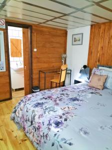 a bedroom with a bed and a table in it at Alojamento Raminho dos Açores in Angra do Heroísmo