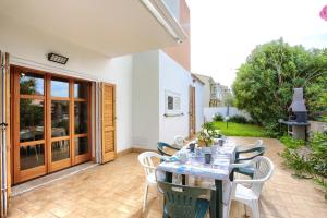 a patio with a table and chairs on a patio at Isola Blu, Jacuzzi & Pool by DomusAway in Porto San Paolo