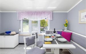 een eetkamer met een witte tafel en roze stoelen bij Beautiful Home In Medulin With 1 Bedrooms And Wifi in Medulin