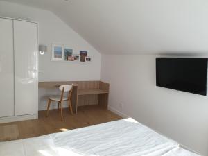 1 dormitorio con 1 cama, escritorio y TV en Messina Apartamenty Wyspa Sobieszewska, en Gdansk