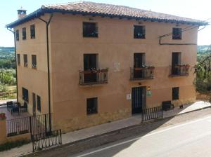 un edificio con ventanas y balcones en una calle en Apartamentos Rurales Rad Icarium en Radiquero