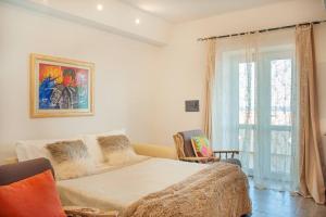 een slaapkamer met een groot bed en een raam bij [Sea Front with View] Elegance in Castelsardo