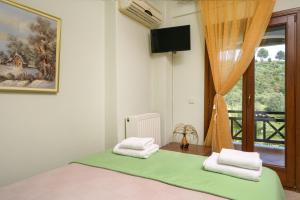 - une chambre avec un lit et une fenêtre avec des serviettes dans l'établissement VILLA MANTI, à Ouranoupoli