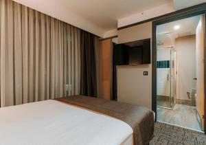 Cette chambre comprend un lit et une porte coulissante en verre. dans l'établissement Invite Hotel Corner Trabzon, à Trabzon
