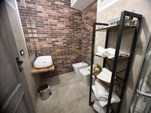 a bathroom with a toilet and a brick wall at Coccia resort / Norcia centro in Norcia