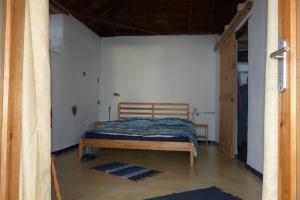 a bedroom with a wooden bed in a room at Casita en el campo con vista al oceano in Tijarafe