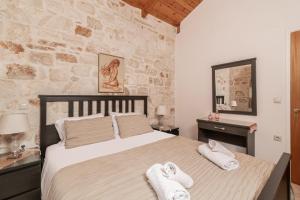 a bedroom with a large bed with towels on it at Vozas Villas - Traditional Houses with Great View in Tragaki