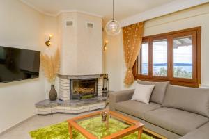 a living room with a couch and a fireplace at VILLA MANTI in Ouranoupoli