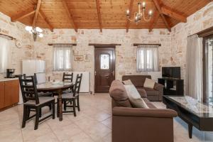 een woonkamer met een bank en een tafel bij Vozas Villas - Traditional Houses with Great View in Tragaki