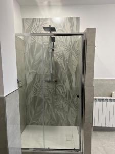 um chuveiro com uma porta de vidro na casa de banho em Hangar Inn em Fiumicino