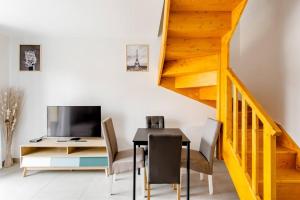 une salle à manger avec une table et une télévision dans l'établissement Joli appartement proche Paris Orly, à Morangis