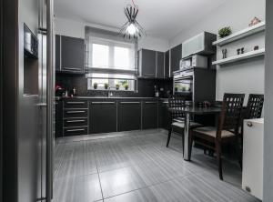 a kitchen with black cabinets and a table with chairs at Villa Lara in Sparti
