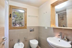 a bathroom with a sink and a toilet and a window at La Perugina by DomusAway in Monte Petrosu