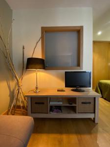 uma sala de estar com televisão numa mesa em Coqueto apartamento centro VIGO con WIFI em Vigo