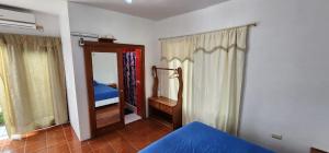 a bedroom with a mirror and a bed in a room at Hostal Poseidon - Neptuno in Puerto Villamil