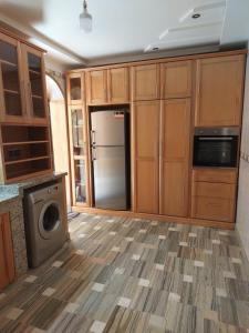 uma cozinha com um frigorífico de aço inoxidável e armários de madeira em Maison de charme em Tiznit