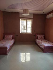 2 Betten in einem großen Zimmer mit 2 Fenstern in der Unterkunft Maison de charme in Tiznit