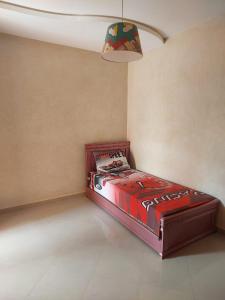 a bedroom with a red bed in a room at Maison de charme in Tiznit