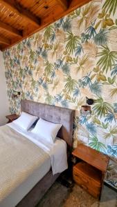 a bedroom with a bed with a tropical wallpaper at Anna Garden Sidari in Sidari