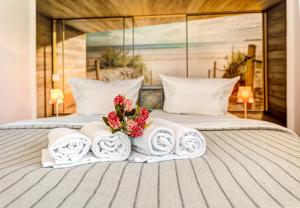 ein Hotelzimmer mit 2 Handtüchern und Blumen auf dem Bett in der Unterkunft Ferienwohnungen zum Ostseestrand in Ahlbeck
