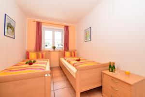 1 dormitorio con 2 camas y una ventana con botellas de vino en Ponyhof Schöllang en Oberstdorf