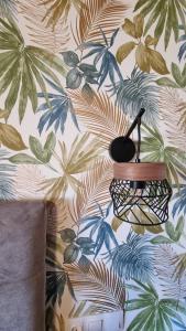 a wall with a tropical wallpaper with a lamp at Anna Garden Sidari in Sidari