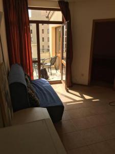 a room with a couch and a view of a balcony at 3 Bedroom Apt with Pool Views at Arcadia Complex in Sunny Beach
