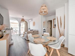 jadalnia ze szklanym stołem i białymi krzesłami w obiekcie Fantastic penthouse with roof terrace in the heart of Nerja w mieście Nerja