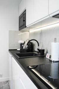 een keuken met een wastafel en een aanrecht bij Apartament Black-Niska z garażem podziemnym in Kielce