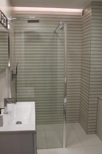 een badkamer met een douche en een wastafel bij Apartament Black-Niska z garażem podziemnym in Kielce