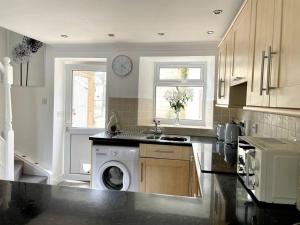 a kitchen with a washing machine in the middle of a kitchen at Cottage in Par, 4mi. from Fowey in Saint Blazey