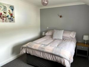 a bedroom with a bed and a painting on the wall at Cottage in Par, 4mi. from Fowey in Saint Blazey