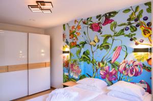 Appart-Hotel Ernz Noire في Grundhof: غرفة نوم مع جدارية زهرة على الحائط