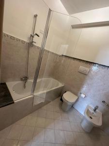 a bathroom with a tub and a toilet and a sink at Hexagon Home (intero appartamento) in Villa San Giovanni