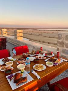 a table with food on it with a view of the desert at Tache By The Lake in Fayoum