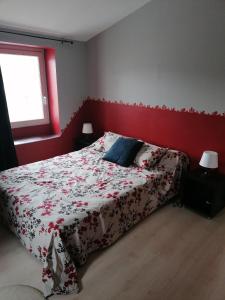 ein Schlafzimmer mit einem Bett mit einer roten Wand in der Unterkunft Maison de village in La Tour-sur-Orb