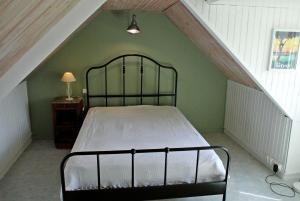 a bedroom with a metal bed in a attic at Sur le sentier des douaniers 3 in Ploubazlanec