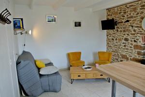 a living room with a couch and chairs and a table at Sur le sentier des douaniers 3 in Ploubazlanec