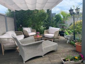 eine Terrasse mit Korbstühlen und einem Tisch in der Unterkunft Fleur in Dudenhofen