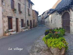 an empty street in an old stone building with flowers at LE GÎTE DU CHEMIN ROUGE 