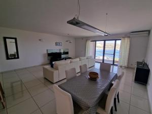 a dining room and living room with a table and chairs at Seafront apartment at Waters' Edge in St Paul's Bay +14 photos