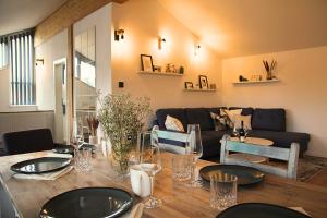 - un salon avec une table et un canapé dans l'établissement Chiemsee Apartments, à Altenmarkt an der Alz