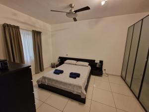 a bedroom with a bed and a ceiling fan at Seafront apartment at Waters' Edge in St Paul's Bay