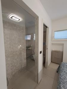 ein Bad mit einer Dusche und einer Glastür in der Unterkunft La Maison Des Arches in Porto Cervo