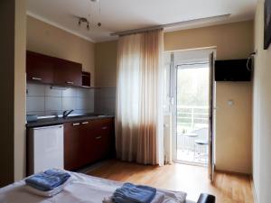 a kitchen with a bed in a room with a window at Villa MILSA Half Board & Pool in Soko Banja