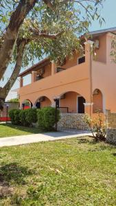 a large orange building with a tree in front of it at Anna Garden Sidari in Sidari