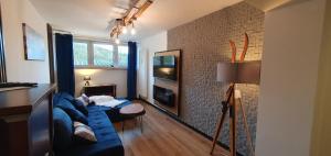 Widokówka في أوسترون: غرفة معيشة مع أريكة زرقاء وتلفزيون